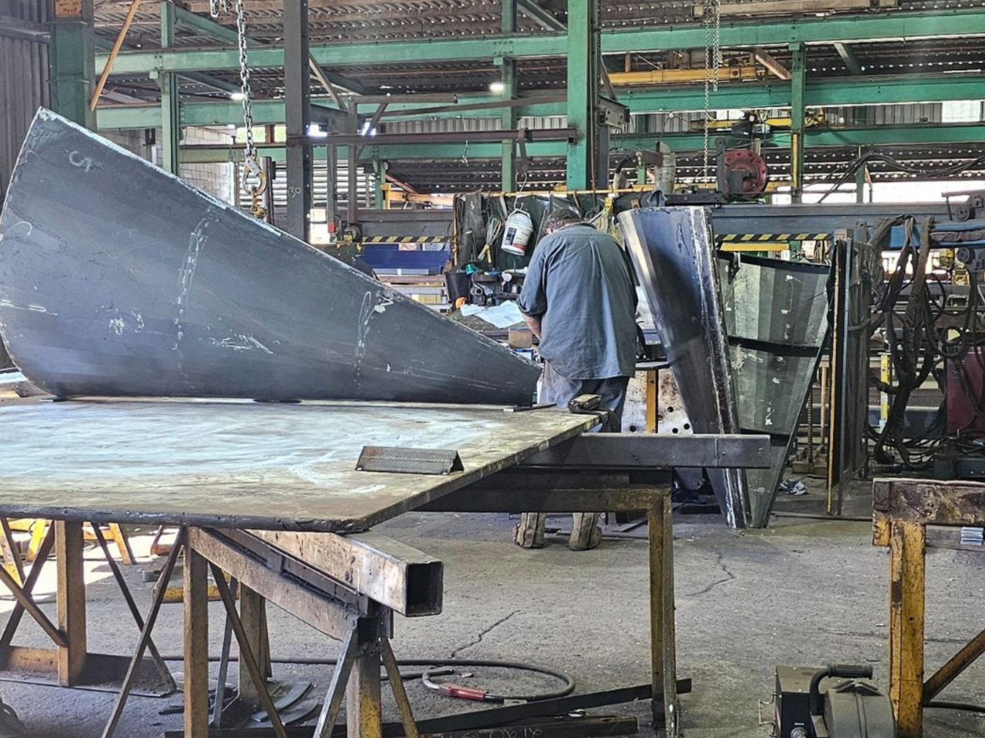 Person in the process of welding custom pumpwell formwork made from steel for sewage project