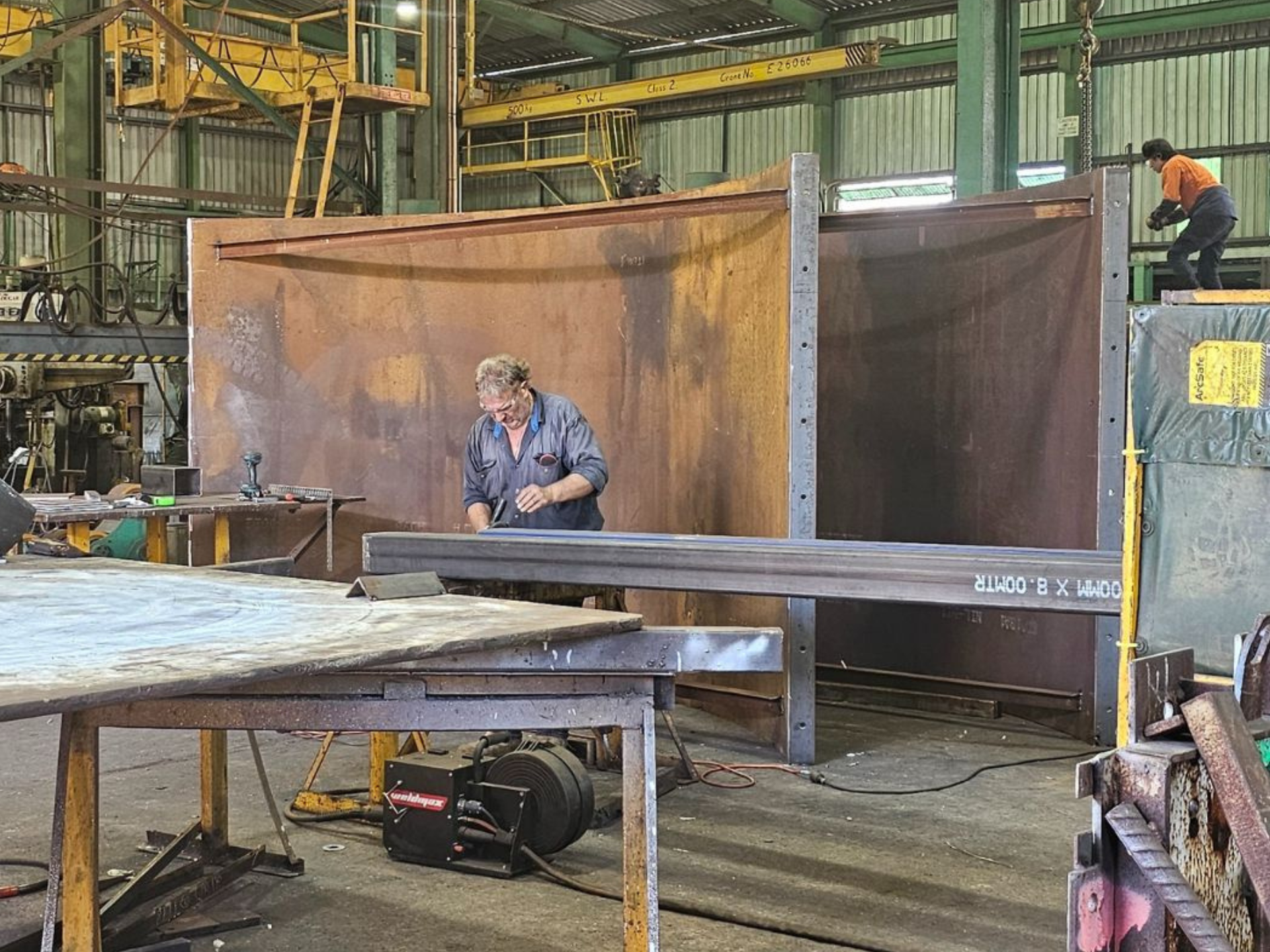 Person welding part of custom pumpwell formwork made from steel for sewage project