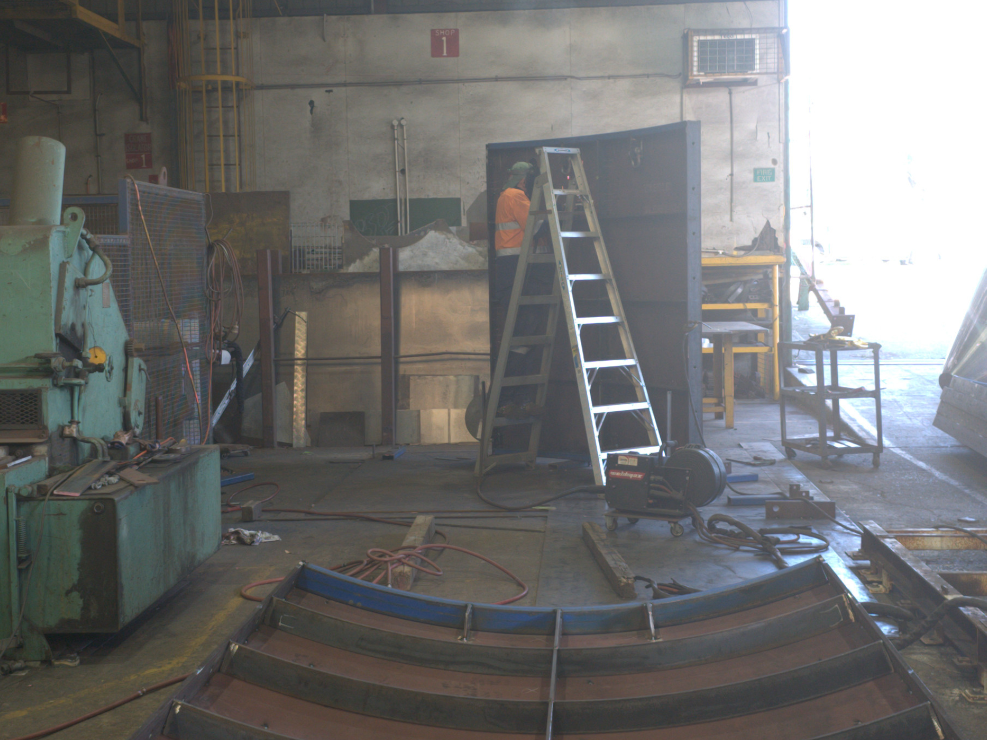 Person on ladder welding custom pumpwell formwork made from steel for sewage project