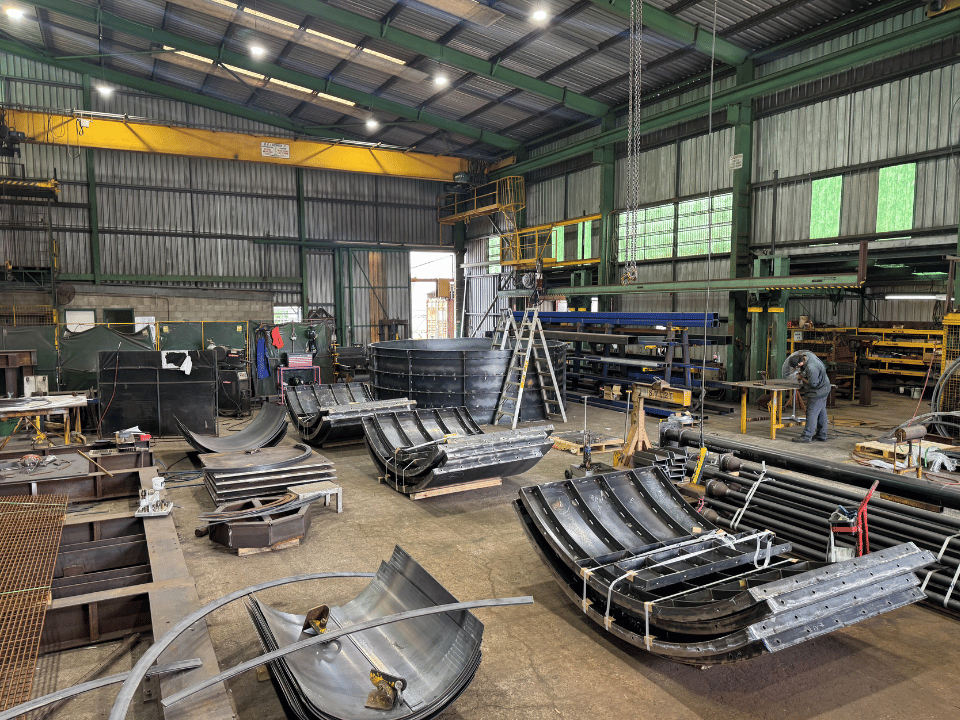 Custom steel formwork frames and curved sections under fabrication