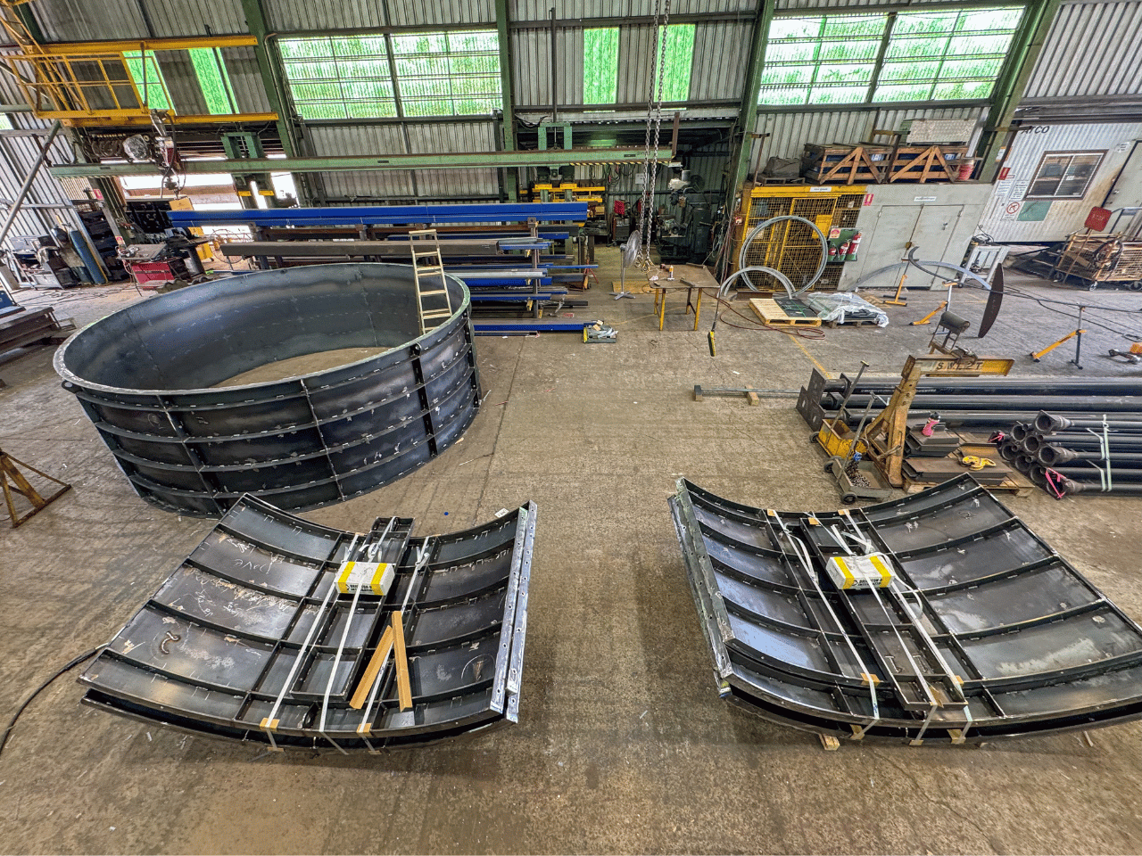 Concrete moulds steel formwork for large sewage pump well laid out on steel fabrication workshop floor ready for dispatch