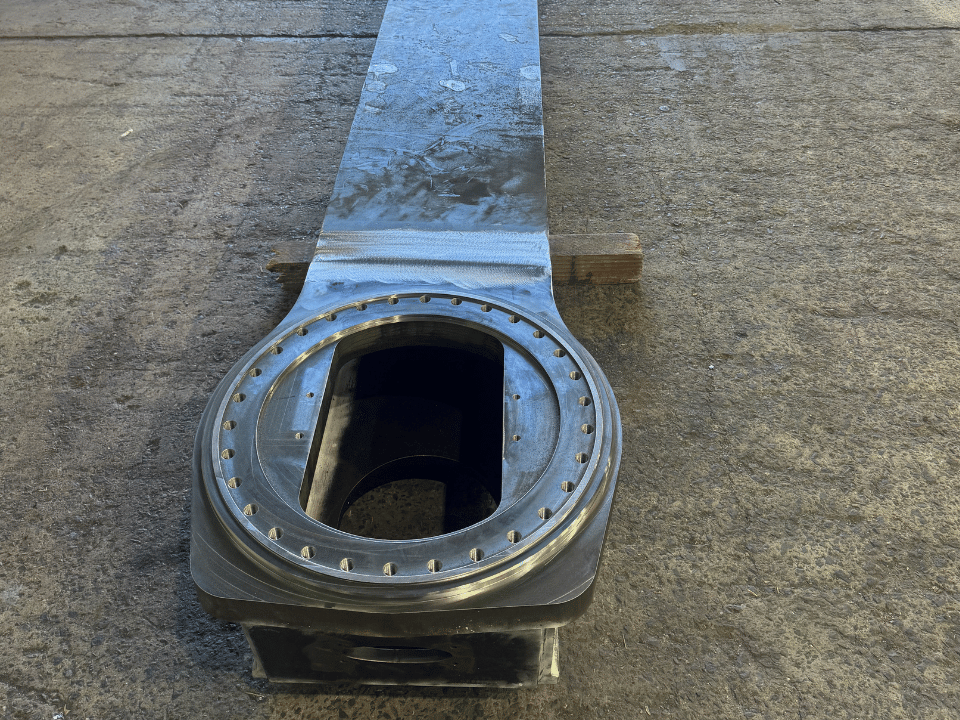 Mining liner handler fabrication showing a structural steel inner beam with a precision-machined circular mounting end.